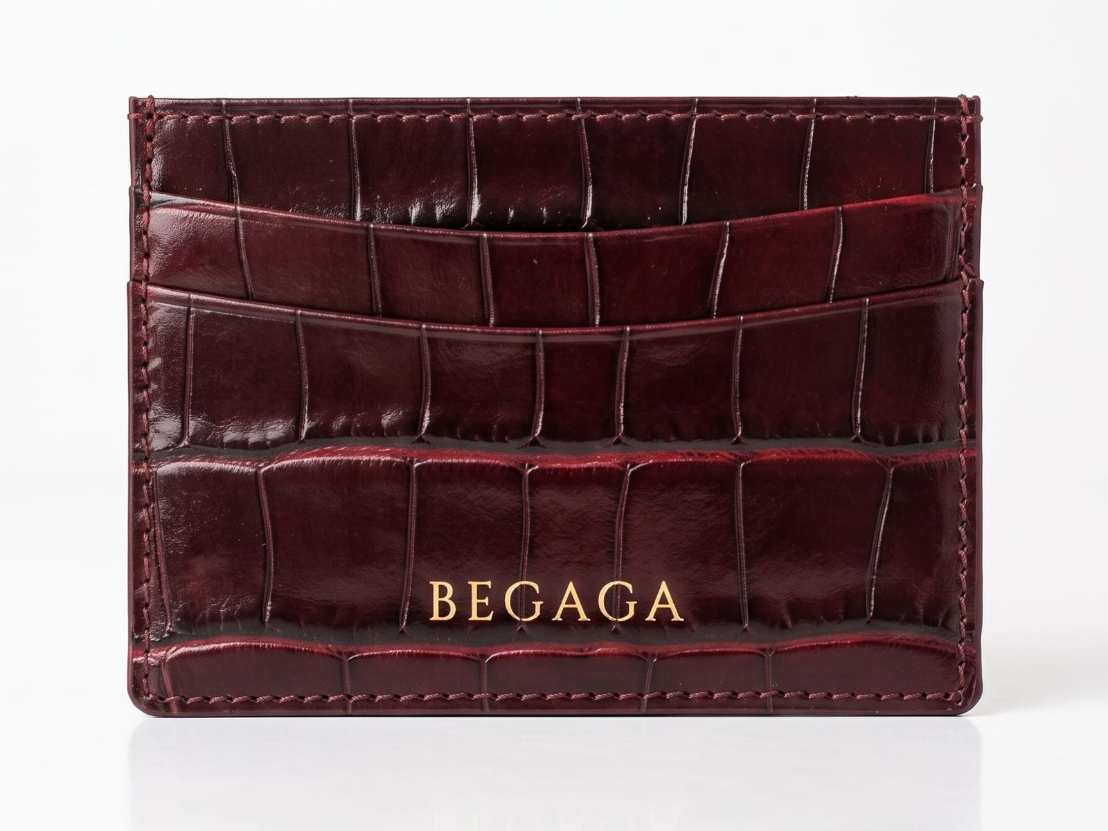 Le porte-cartes Maison Begaga en cuir de veau embossé croco bordeaux, logotype BEGAGA marqué à l'or à chaud.